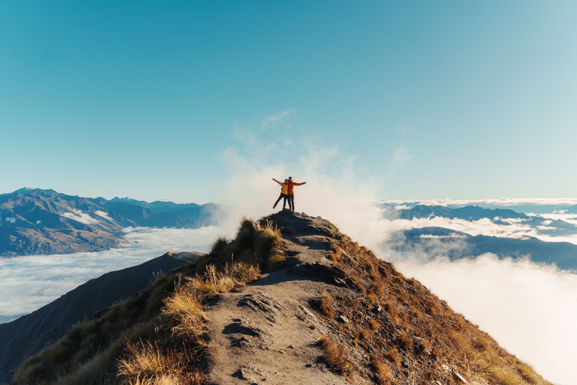 Couple hiker standing on Roys Peak mountain with foggy in the morning at New Zealand
