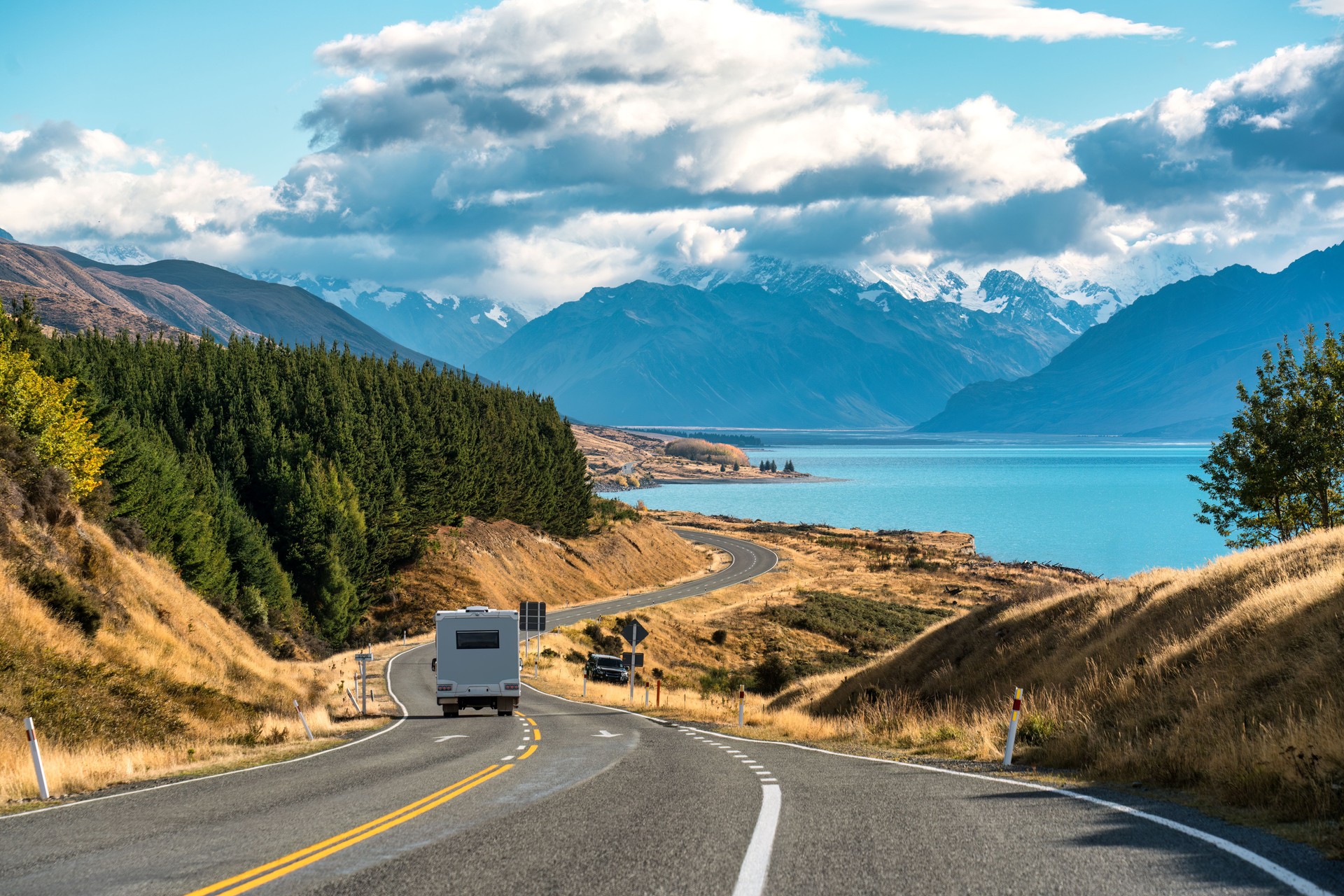 Road trip of Mt Cook over winding road with motorhome driving on sunny day at Peters lookout, New Zealand